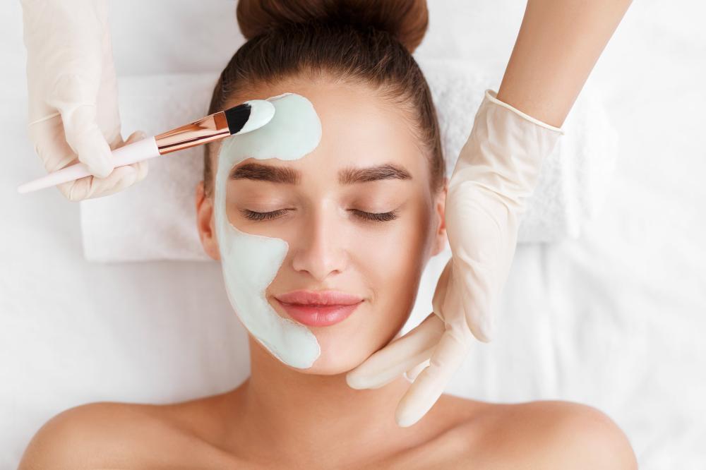 Femme se faisant poser un masque à l'argile sur le visage
